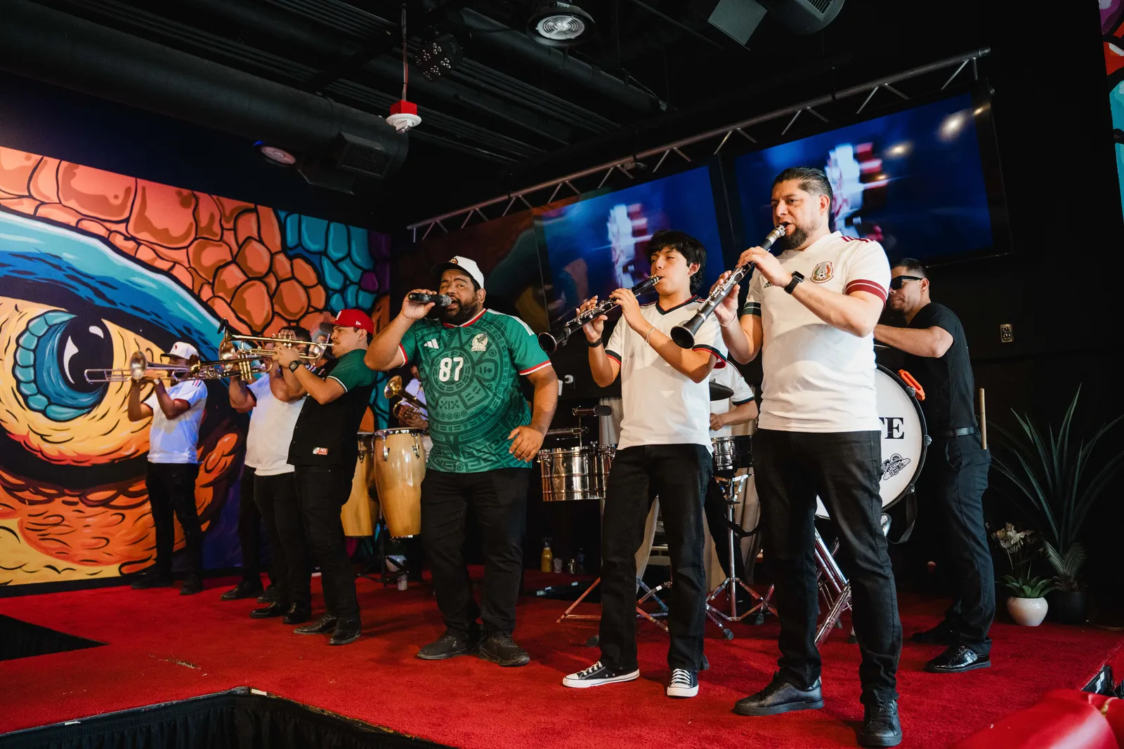 Banda singers performing under the alebrije murals